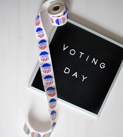 I Voted sticker roll over Voting Day sign