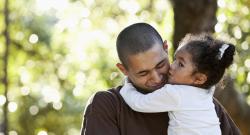 Smiling father with a young daughter in his arms