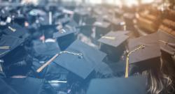 Cap and gowned students facing away at a graduation ceremony