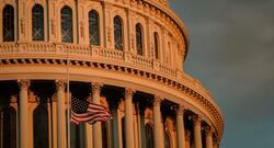 Capitol building at sunset with flag at half mast