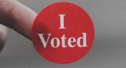 Close up of a red "I Voted" sticker. 