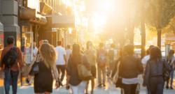 People walking down street at sunset