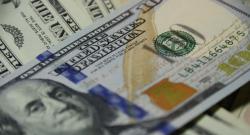 stacks of one-hundred-dollar bills with camera focus on the phrase "The United States of America"