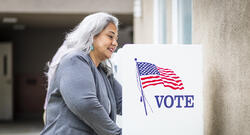 Latina woman voting at a voting booth