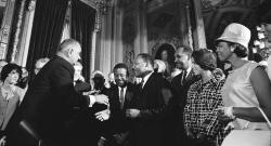 Lyndon Johnson shakes Martin Luther King, Jr.'s hand after signing the Voting Rights Act of 1965