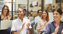 Diverse audience smiling and clapping