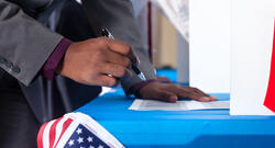 Black voter hovering over a former with a pen