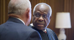 Justice Clarence Thomas speaking with another person