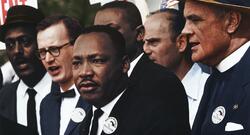 Dr. Martin Luther King standing along other civil rights organizers at a march