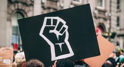 Black sign with a fist in a Black Lives Matter protest