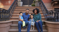 Black family sitting on their front steps