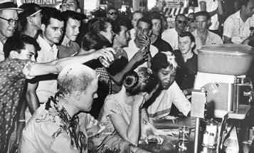 Jackson, MS, Woolworth Lunch Counter Sit-In —white men pouring sugar on the heads of protestors and a woman of color