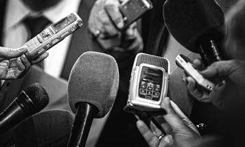 Microphones and recording devices gathered around a person