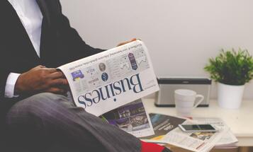 Business man reading the business section of a newspaper