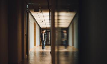Student walking down dark hallway