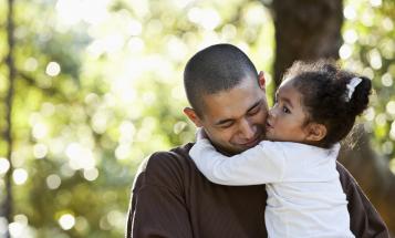 Smiling father with a young daughter in his arms