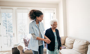 Home care aide helping an elderly black woman