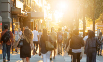 People walking down street at sunset