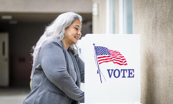 Latina woman voting at a voting booth