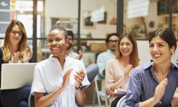 Diverse audience smiling and clapping