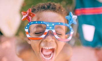 Happy child with American flag glasses on