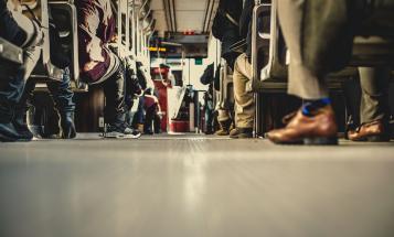 Feet of people sitting on a bus, from a low angle