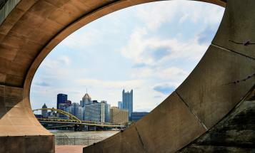 Pittsburgh skyline seen through the Fred Rogers Memorial Monument in foreground