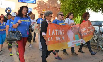 Latinas marching with a banner for love and liberation