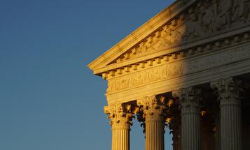 Supreme Court building cast half in light and half in shade from setting sun