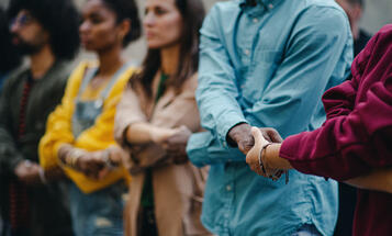 Multiracial group holding hands