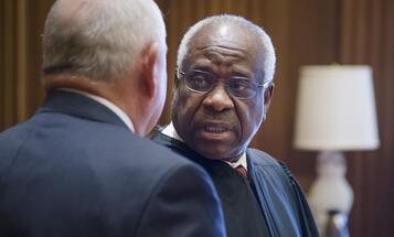 Justice Clarence Thomas speaking with another person