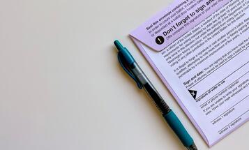 Pen next to voter registration form and envelope