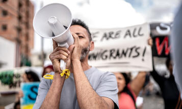 Mature man talking in a megaphone during a protest in the street