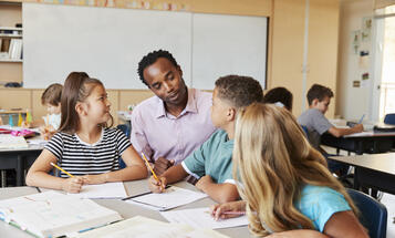 Teacher working with elementary school kids at their desk