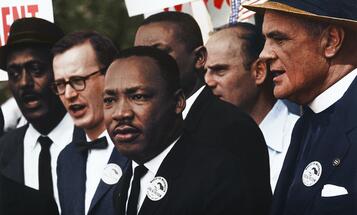 Dr. Martin Luther King standing along other civil rights organizers at a march