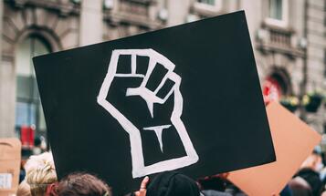 Black sign with a fist in a Black Lives Matter protest