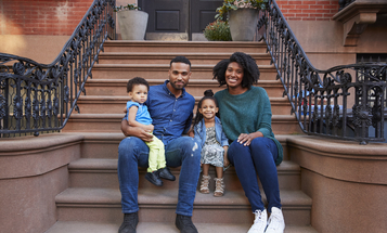 Black family sitting on their front steps