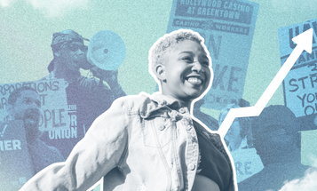 A woman smiling in front of organizers with rally signs 