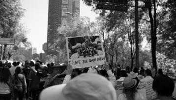 Person at rally holding sign with Martin Luther King's picture and caption "I have the same dream"