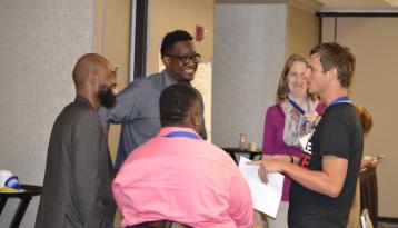 Group of people informally talking and smiling in a conference room