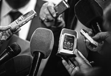 Microphones and recording devices gathered around a person