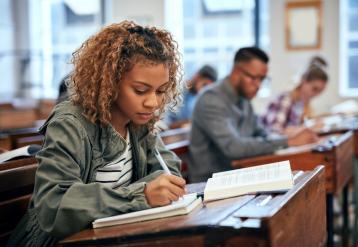 Black student in classroom, writing