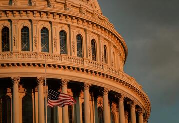 Capitol building at sunset with flag at half mast