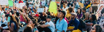 Black woman kneeling at a protest