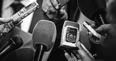 Microphones and recording devices gathered around a person
