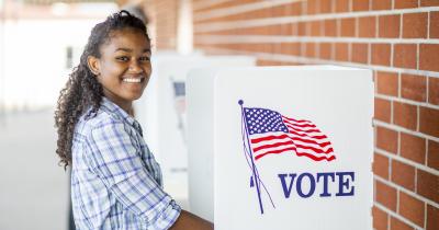 Young smiling voter at voting booth