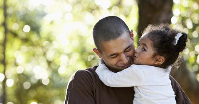 Smiling father with a young daughter in his arms