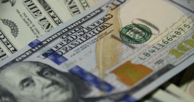 stacks of one-hundred-dollar bills with camera focus on the phrase "The United States of America"