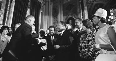 Lyndon Johnson shakes Martin Luther King, Jr.'s hand after signing the Voting Rights Act of 1965