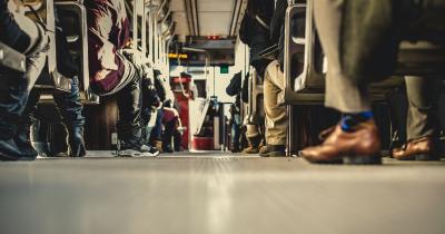 Feet of people sitting on a bus, from a low angle